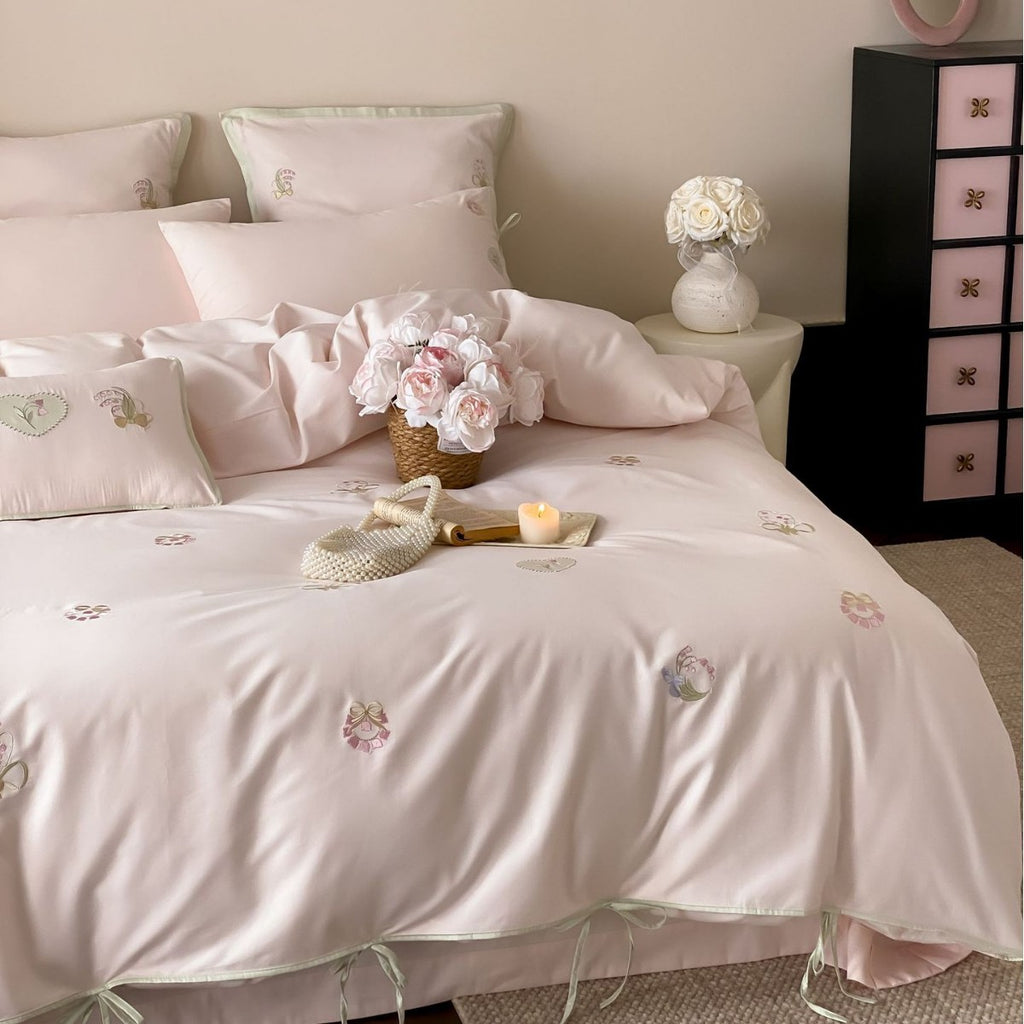 Embroidered cotton satin bedding set with decorative ribbons and floral appliqués
