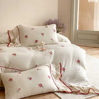Bedding set made of cotton percale with frill hem, floral embroidery, and decorative ribbons