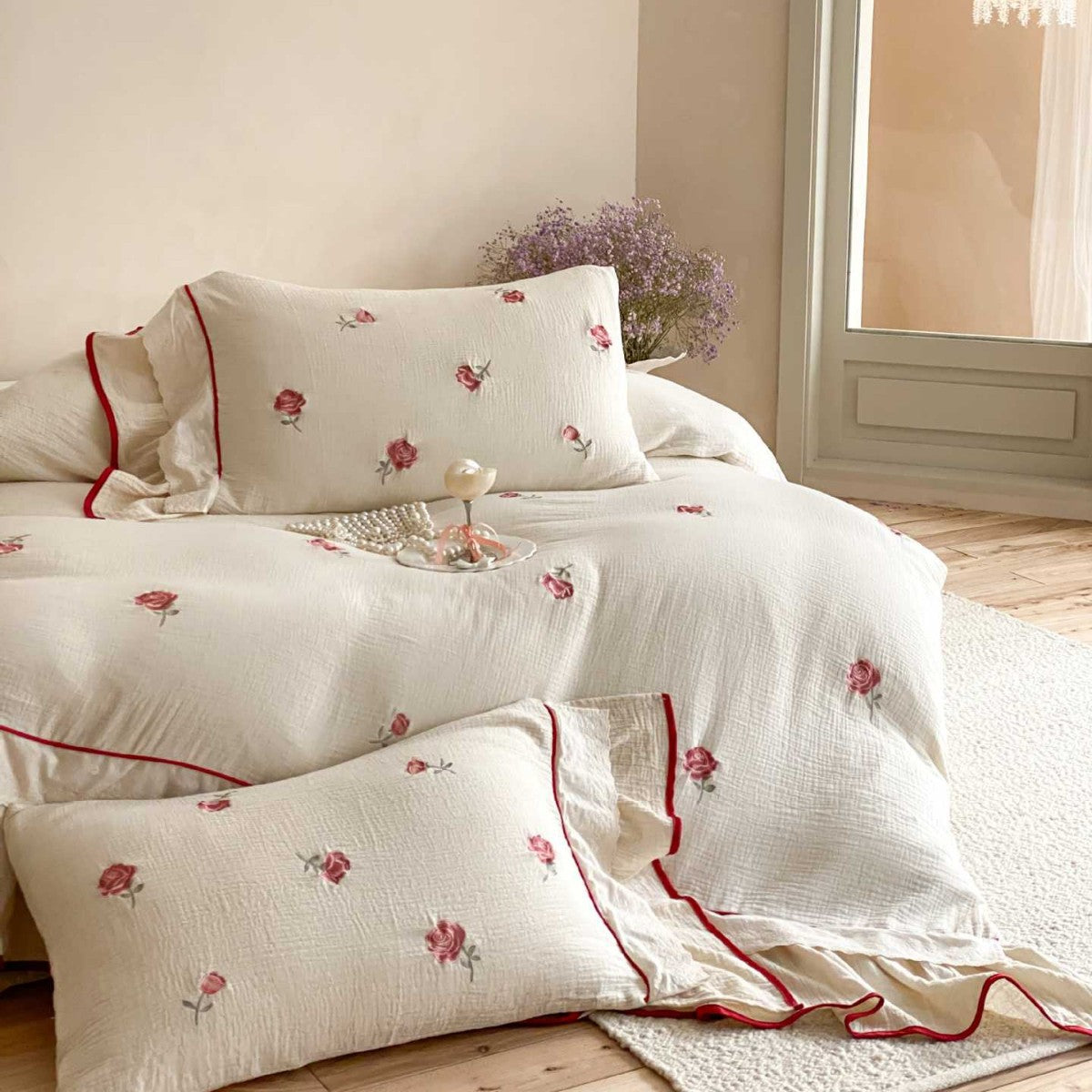 Bedding set made of cotton percale with frill hem, floral embroidery, and decorative ribbons