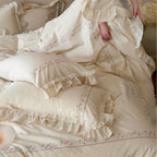 Vintage-inspired cotton bedding set with ruffles, delicate floral embroidery, and lace trim