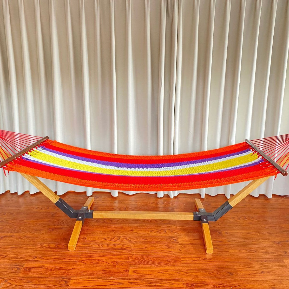 Woven cotton hammock with wooden spreader bars and freestanding stand
