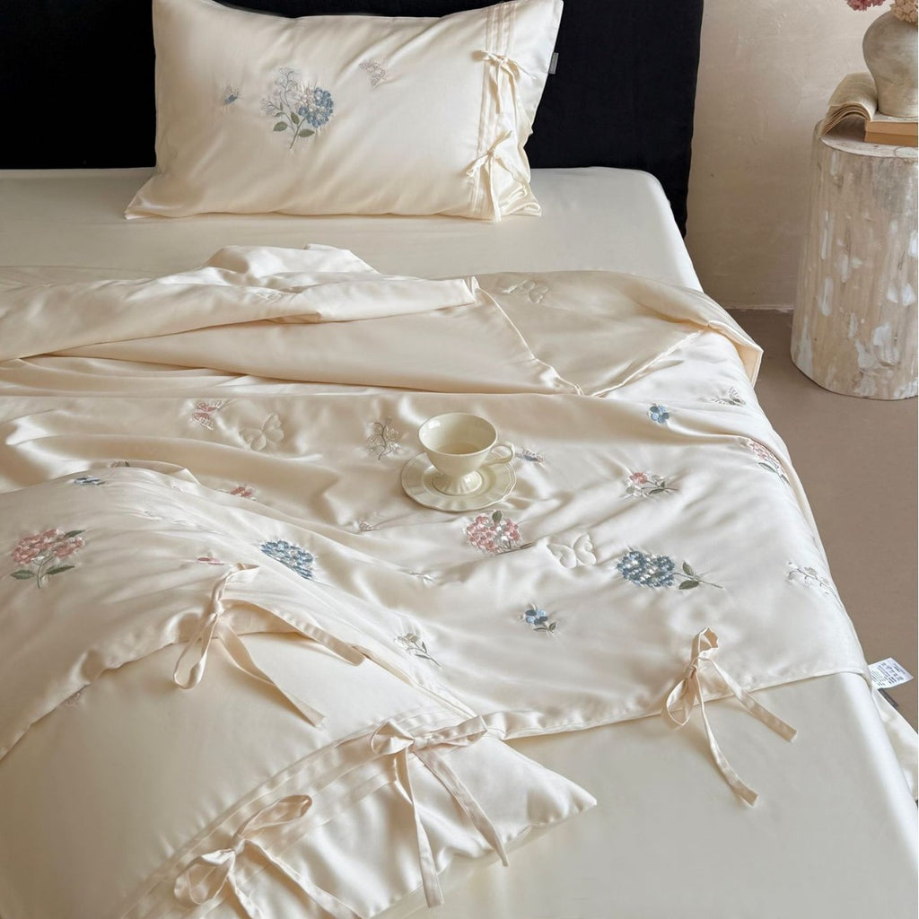Satin bedding set with floral embroidery, tie ribbons, and silky glossy finish